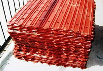A pile of red clamping plates placed on the ground